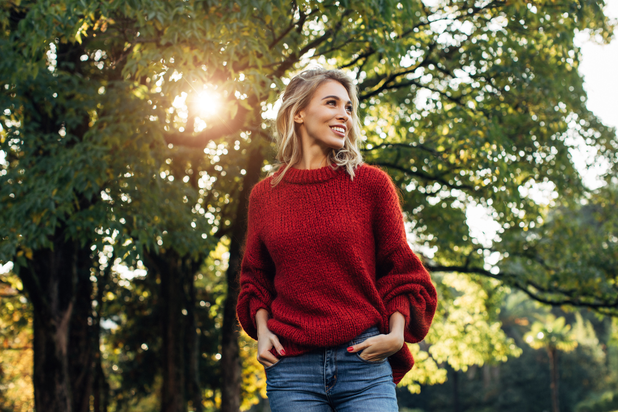 Woman smiling in front of a tree.