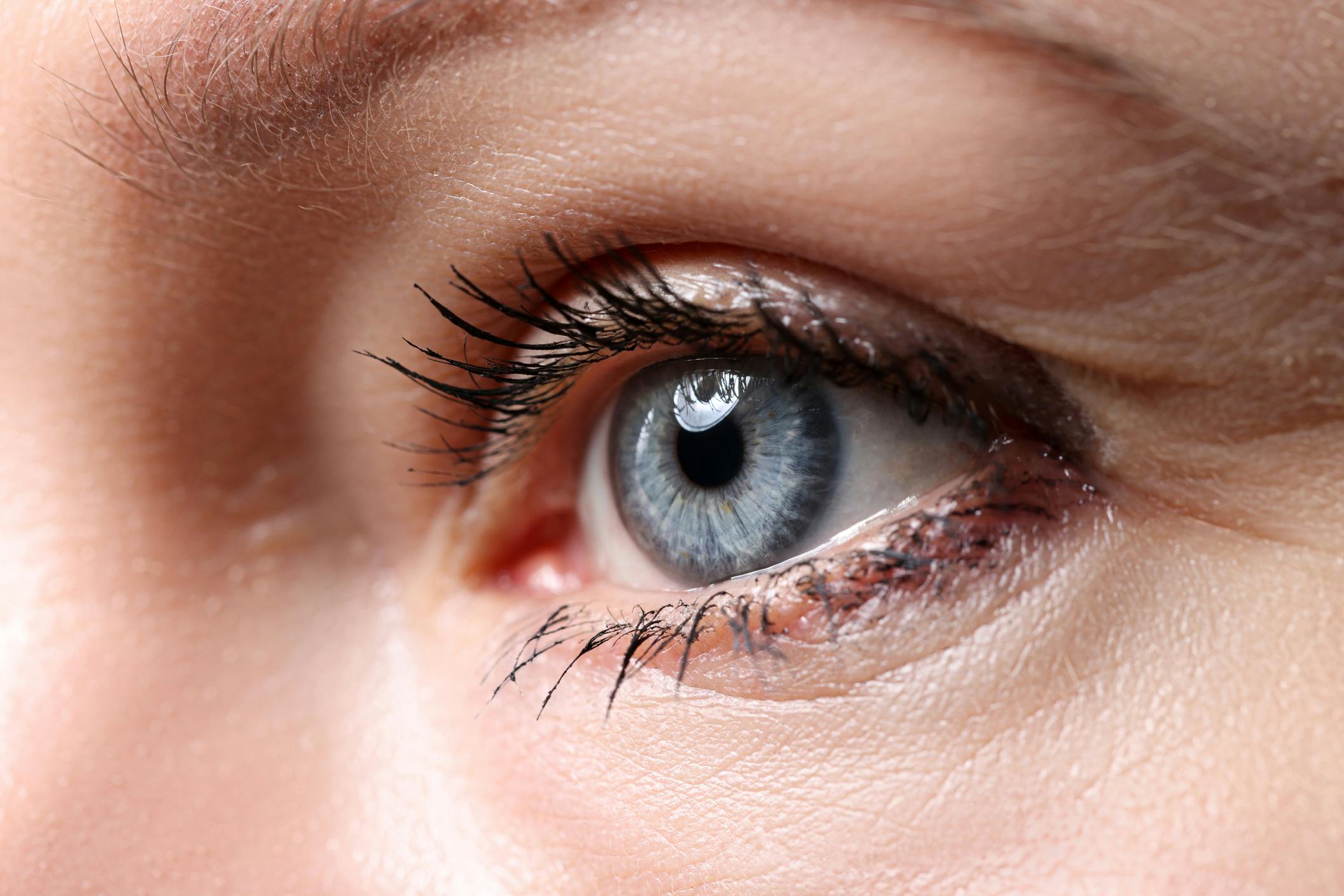 there is a close up of a woman's eye with a blue eye