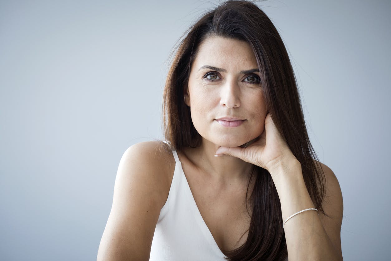 Brunette woman holding her face in her hand