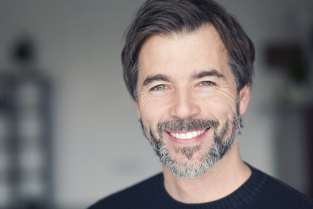 An older man with a beard smiling