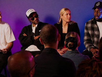 Panel of speakers on a purple-lit stage