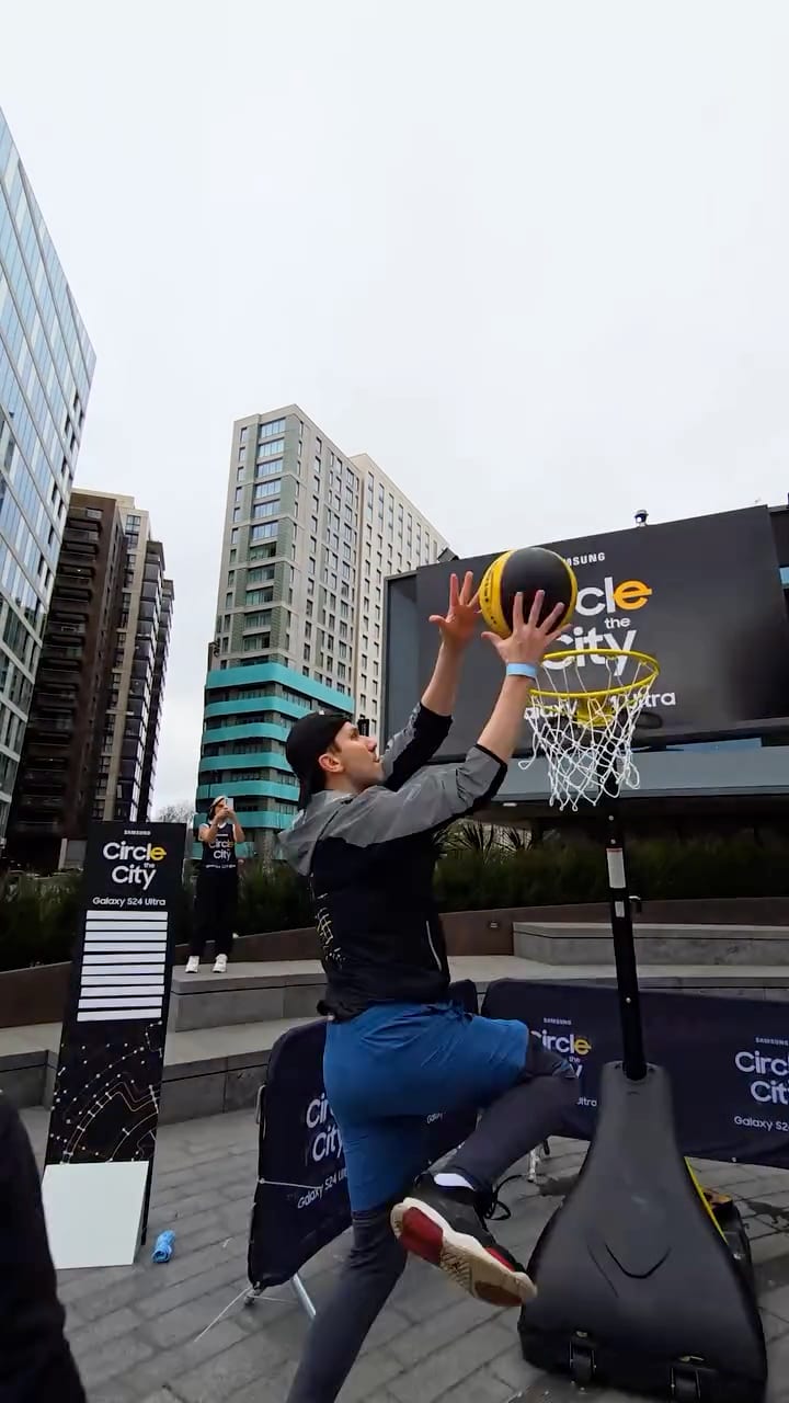 Person holding a Samsung phone in front of a city advert