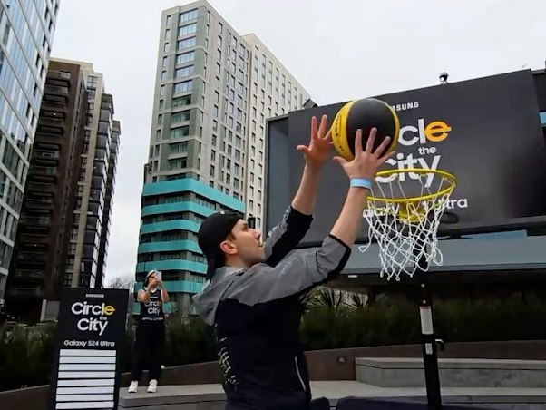 Person holding a Samsung phone in front of a city advert