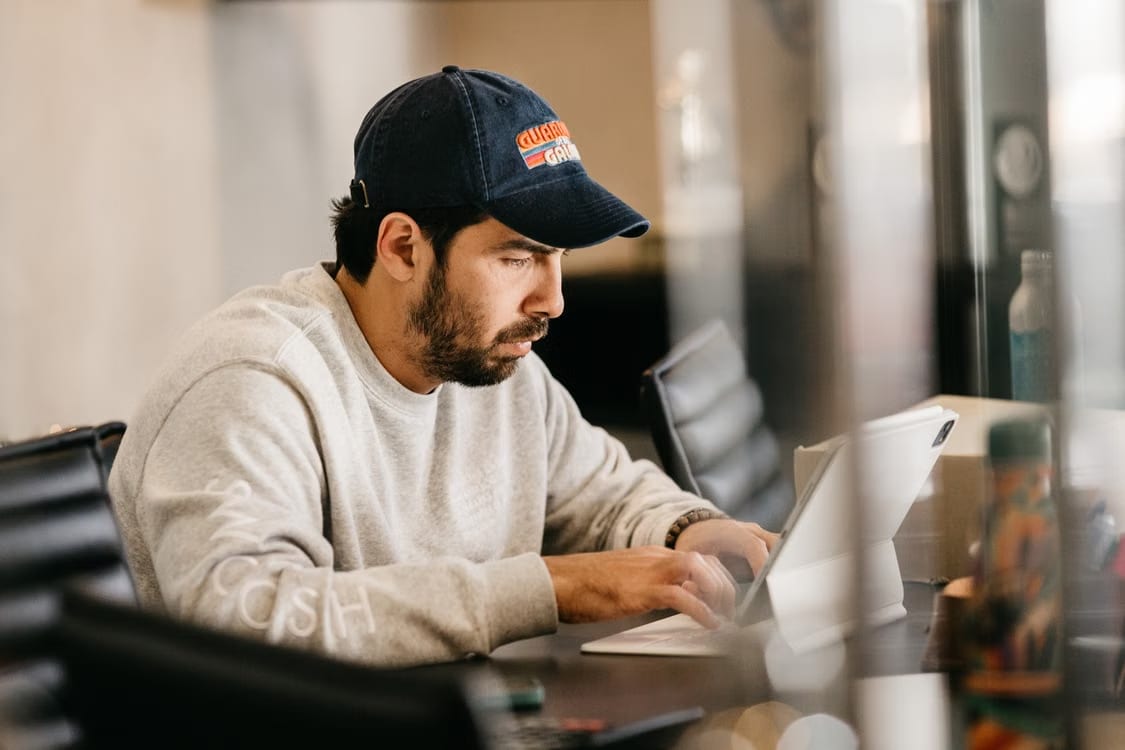 Man in a cap working at a laptop