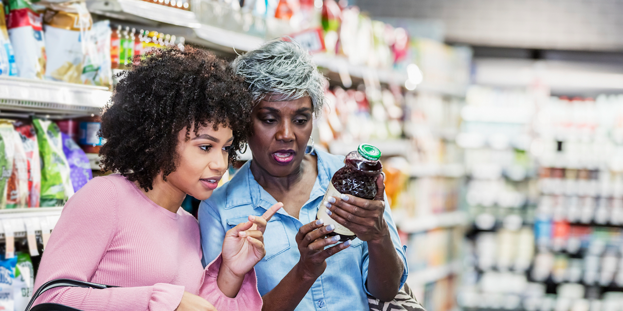 Women reading the Nutrition facts of a product Two women at a supermaket checking the Nutrion facts of a product
