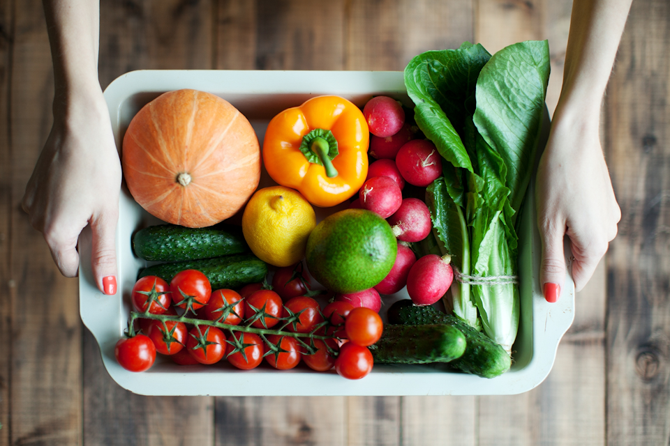 Person holds a tray with vegetables full of vitamins and minerals