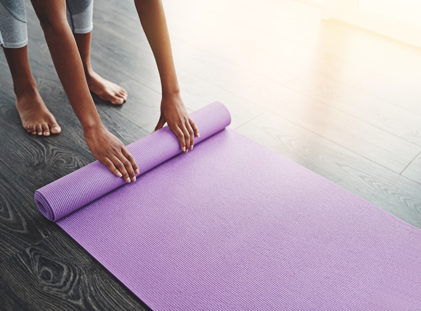 Person unrolling her yoga mat at the beginning of a flex class
