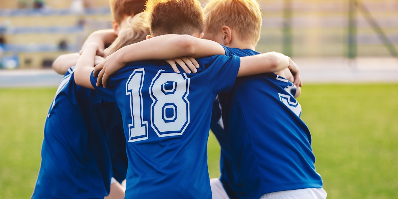 Kids playing soccer Kids huddling before soccer match