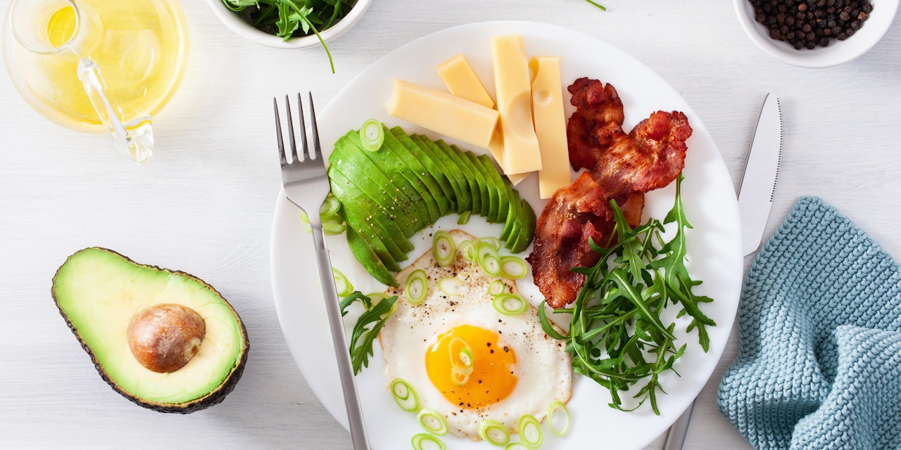 Healthy keto breakfast plate with egg, avocado, cheese, bacon