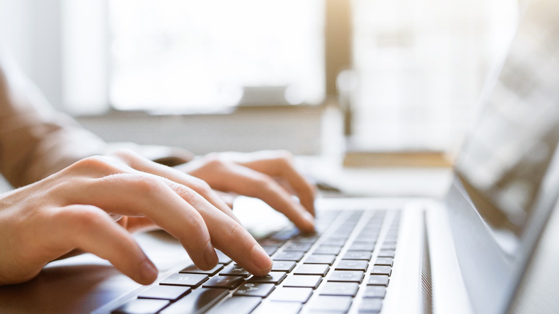 Hands typing on a notebook