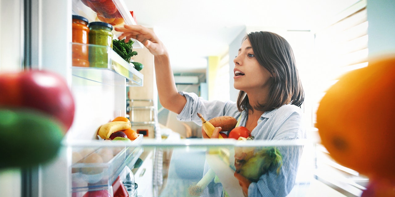 Woman picking ingredients Woman picking healthy ingredients from the fridge