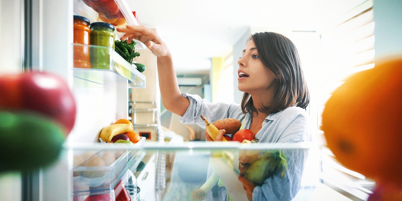 Woman picking healthy ingredients from the fridge