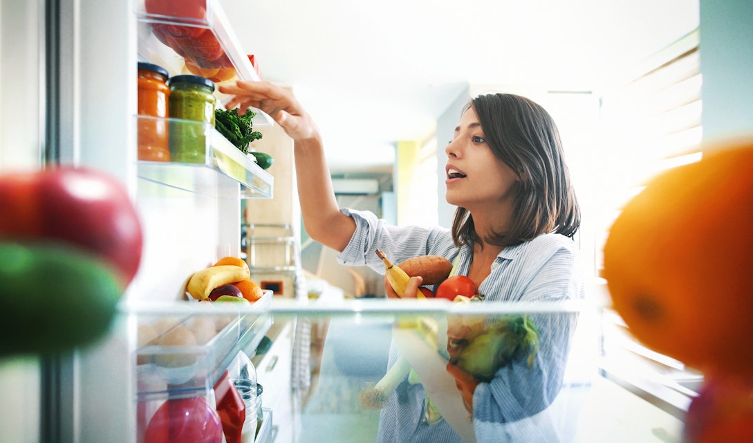 Woman picking healthy ingredients from the fridge