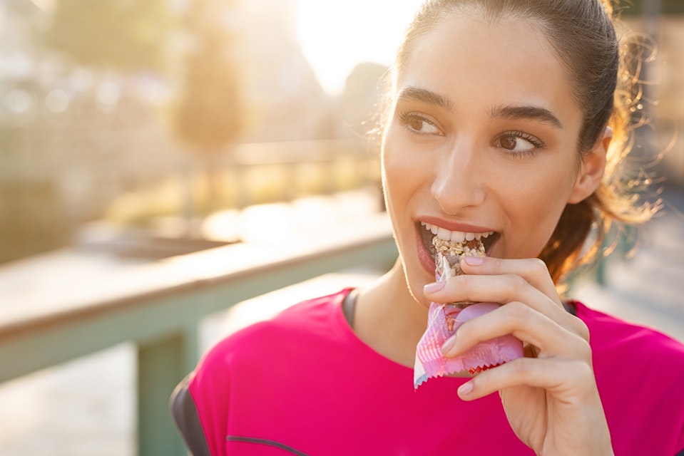 Woman eating protein bar during workout