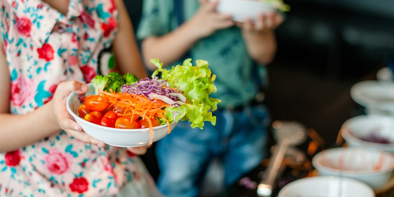 Child holding a salad bowl