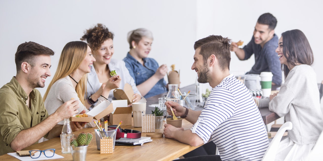 Coworkers eating a healthy lunch at the office together