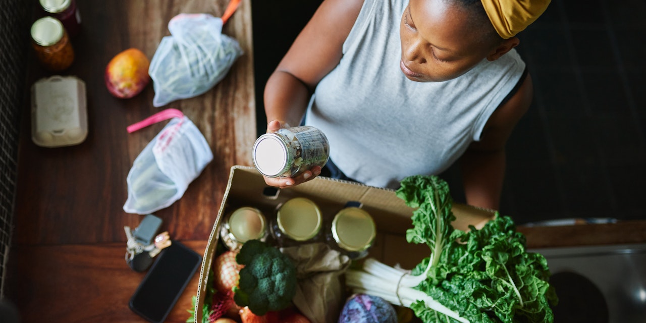 Woman unpacking healthy groceries at her kitchen