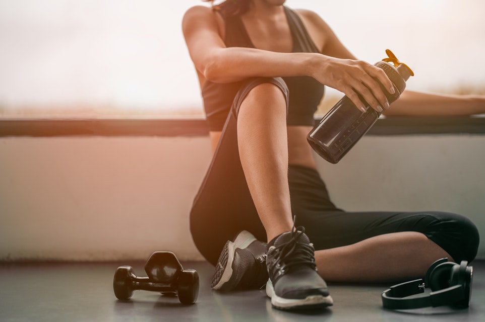 Woman relaxing after a workout and drinking whey protein