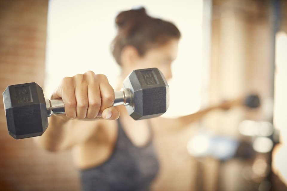 Woman lifting dumbbells in the gym