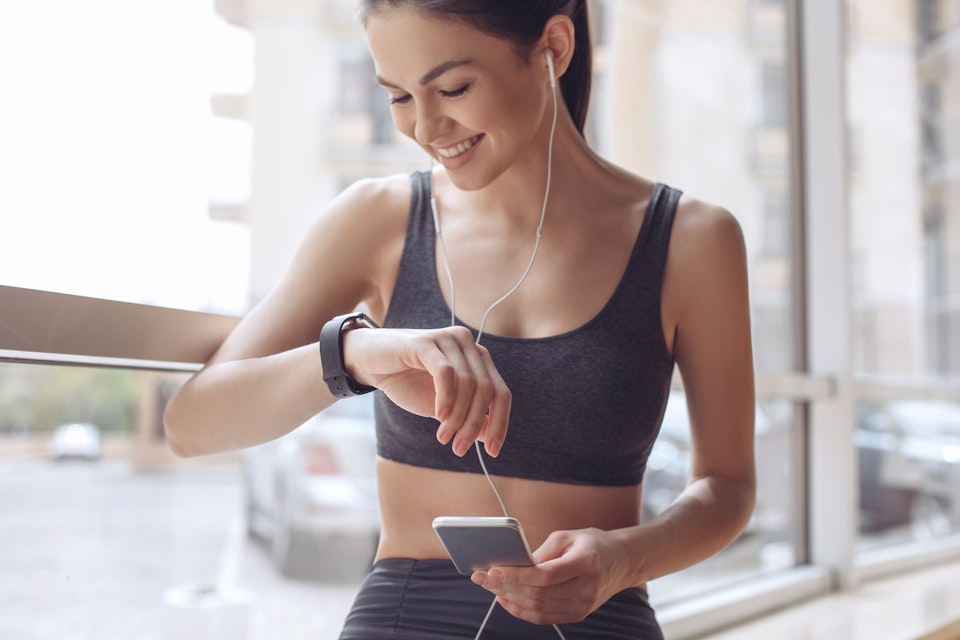 Woman training and monitoring her progress on her phone and smartwatch