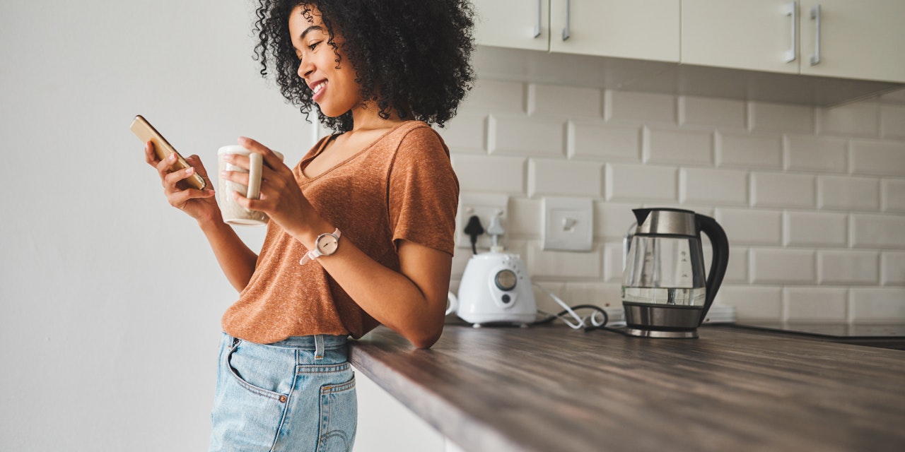 Woman using Lifesum on her phone at her kitchen