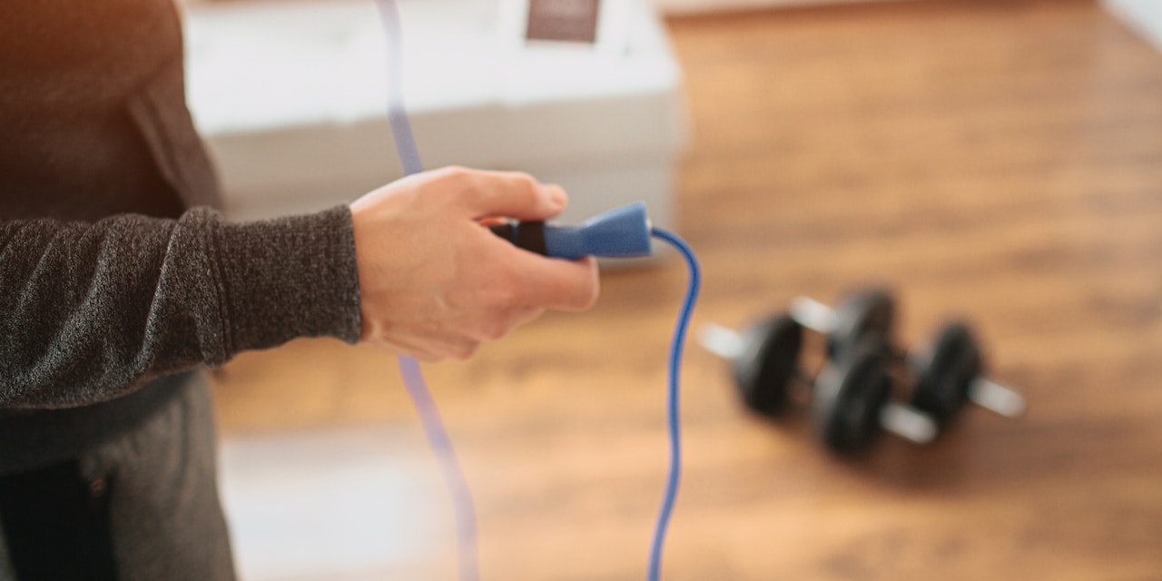 Man working out at home with a jump rope