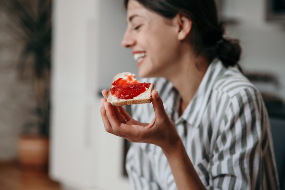 Young happy woman eating a sandwhich