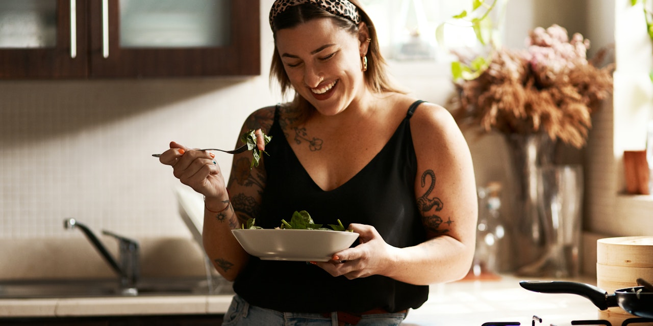Woman enjoying healthy salad Woman happy about her balanced meal