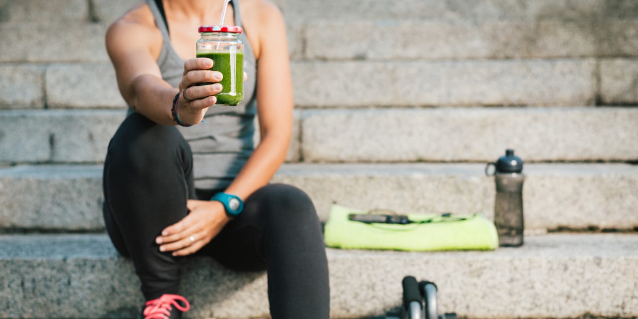 Healthy smoothies for muscle buildingh Woman holding a green smoothie