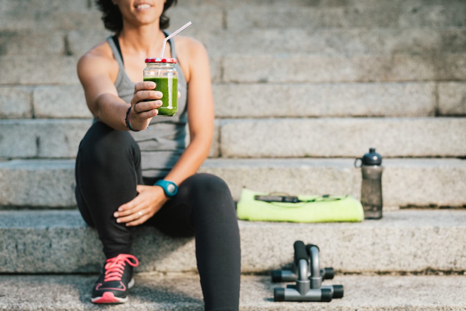 Woman holding a green smoothie