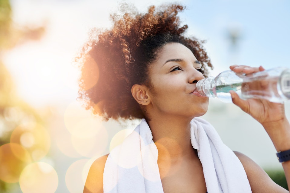 A young woman drinking water from a bottle