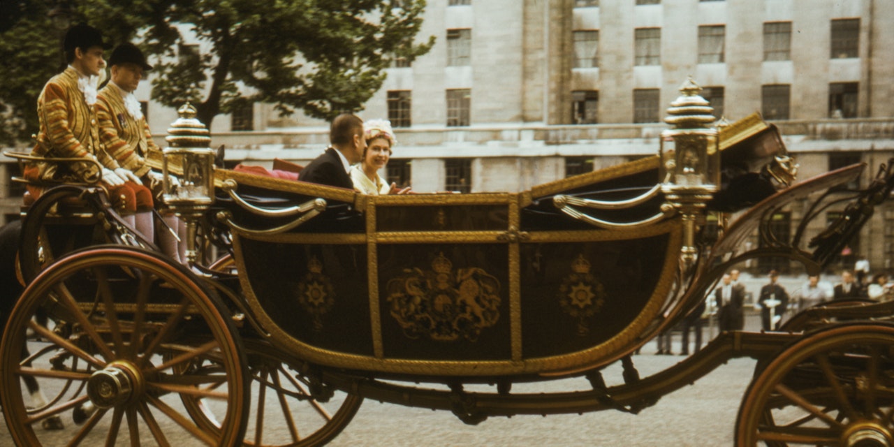 Queen Elizabeth riding in a royal carriage Queen Elizabeth in the younger days of her reign.