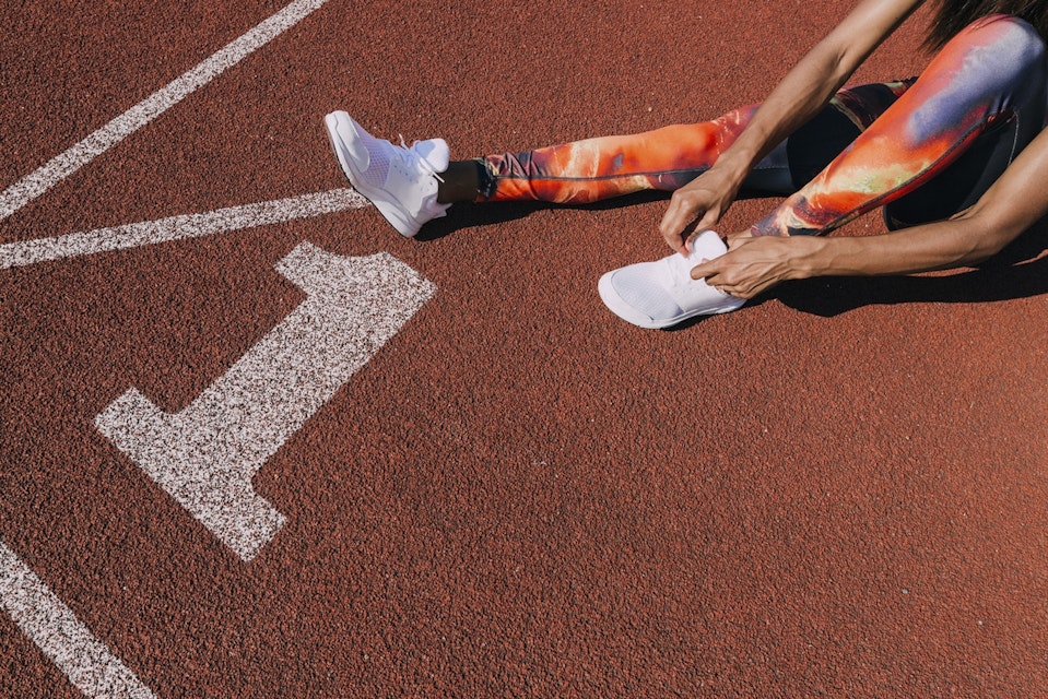 Girl tying her shoes on running track