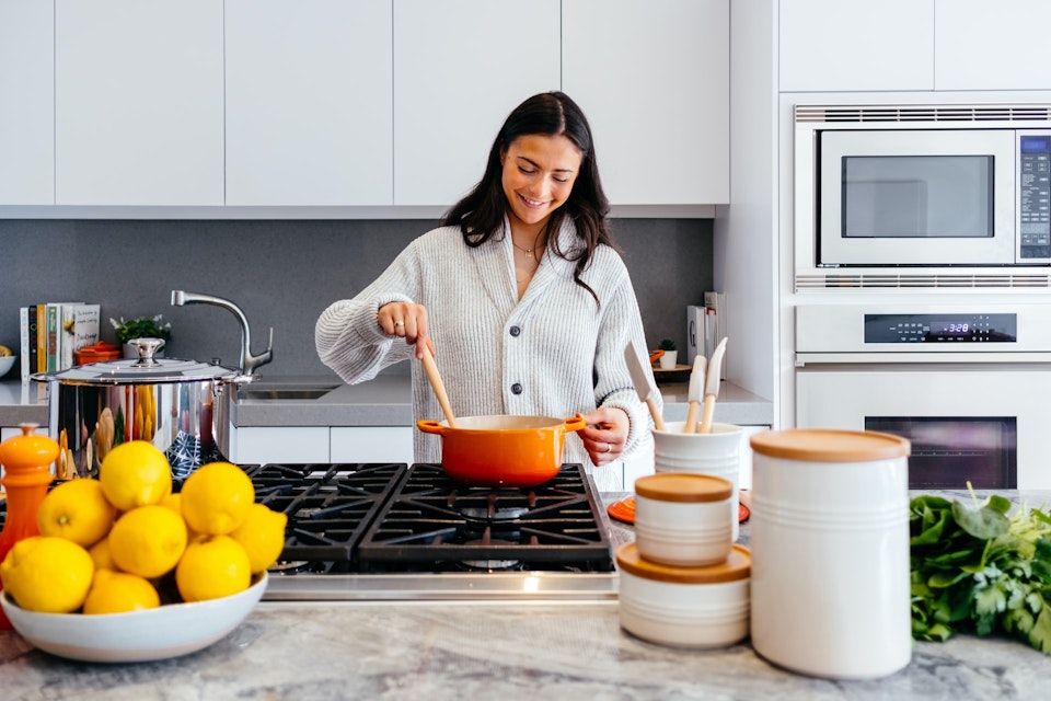 Woman cooking in a grey kitchen