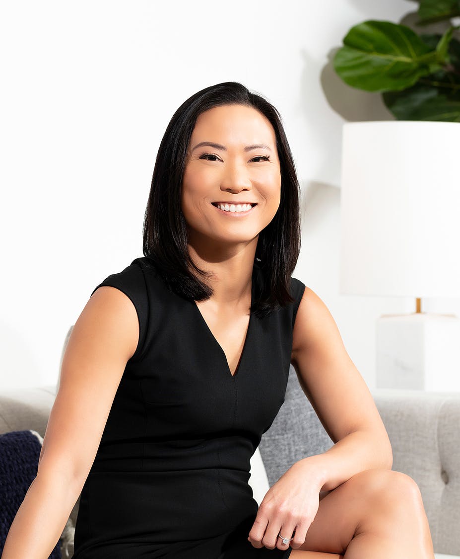 Dr. Tansavatdi sitting on couch in black dress smiling