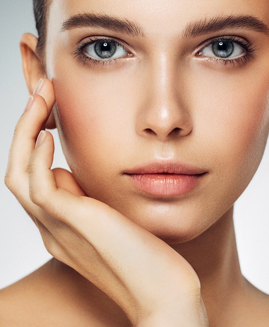 Woman with serious smile touching her face