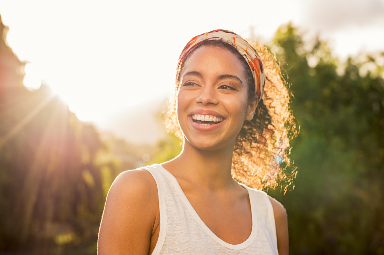 beautiful woman smiling with the sun behind her