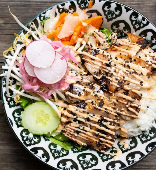 Bol de riz garni de porc grillé, radis, carotte marinée, concombre et fèves germées, nappé de mayo