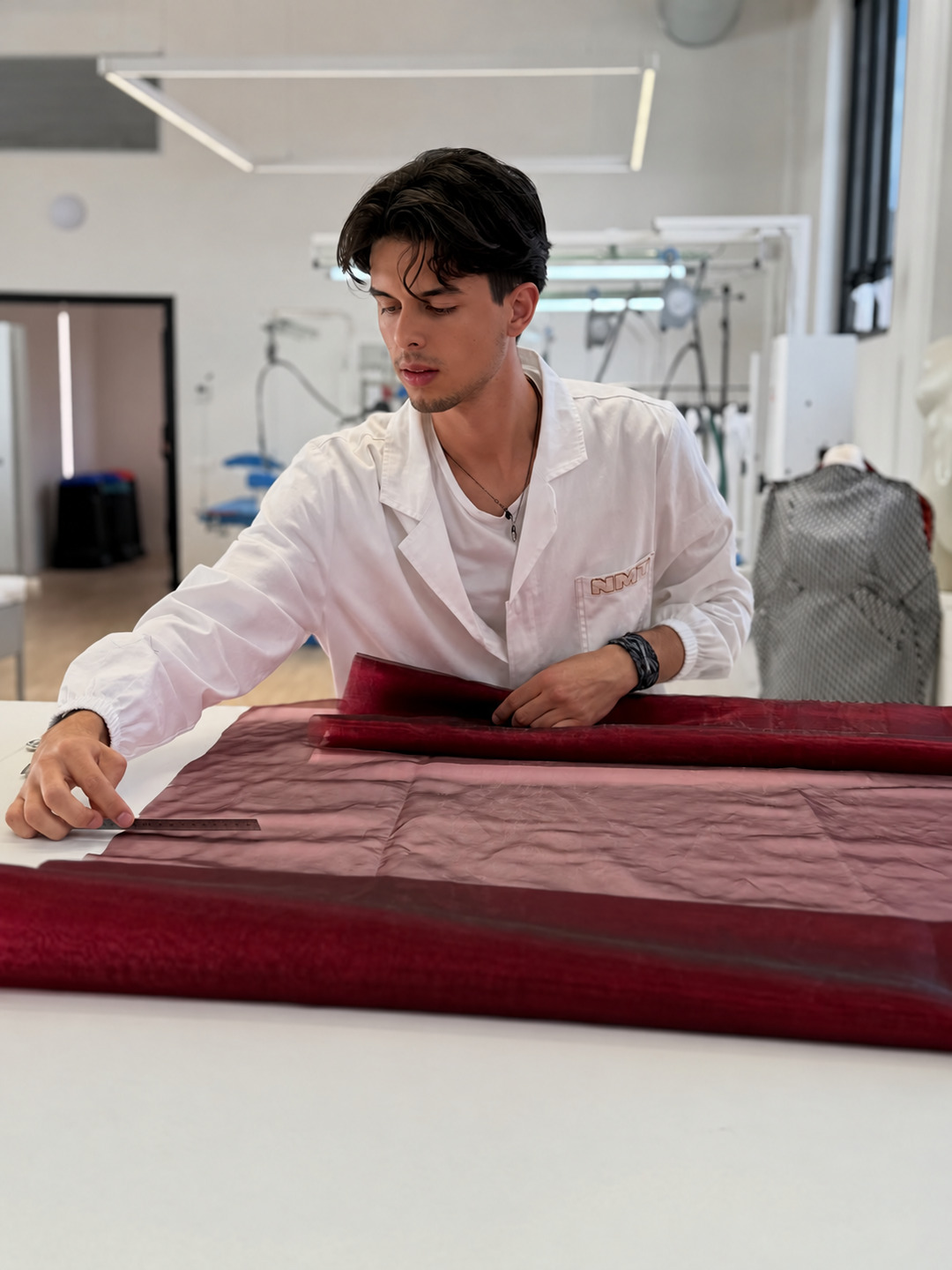 Studente misura e taglia un tessuto in laboratorio
