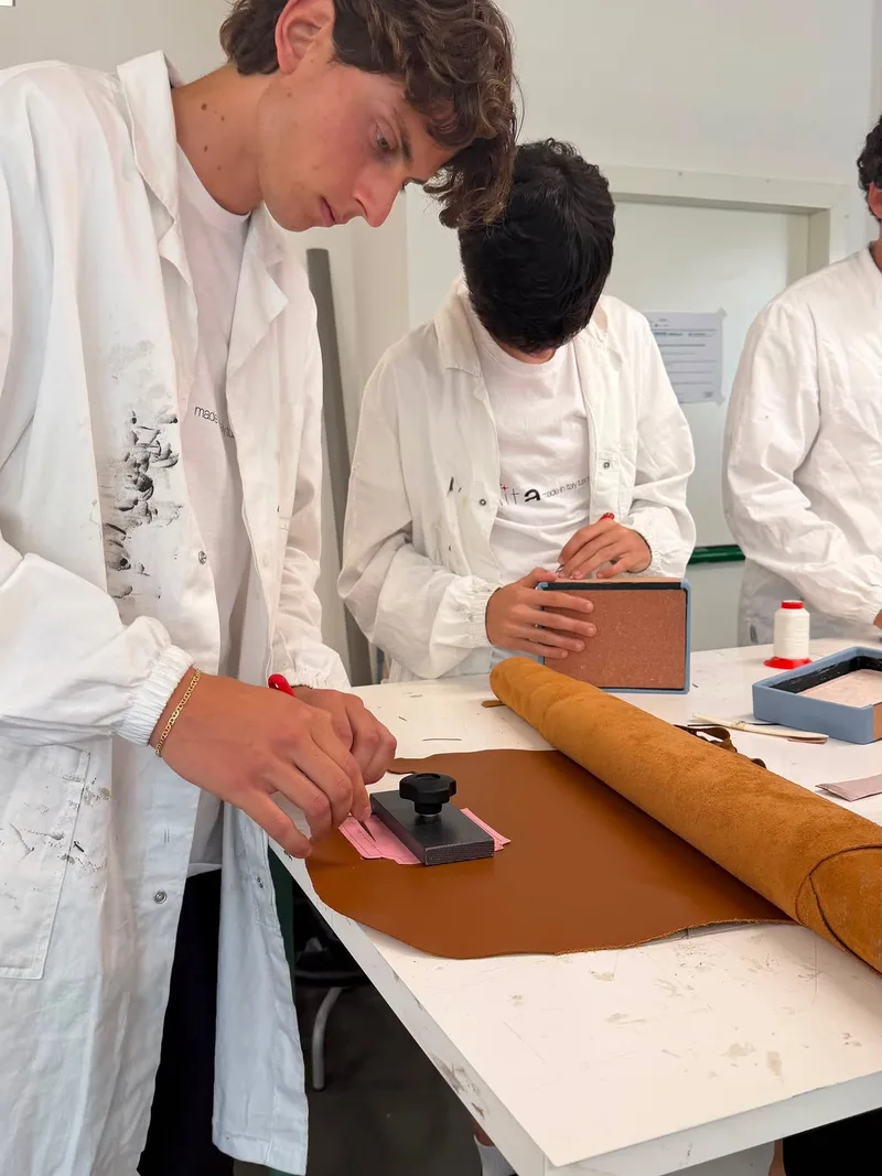 Studenti lavorano la pelle al banco di laboratorio