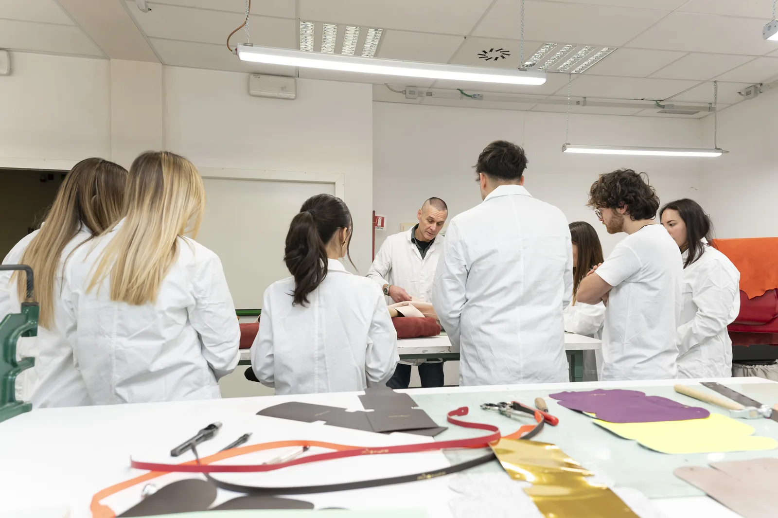 Studenti e docente al lavoro tra banchi e materiali