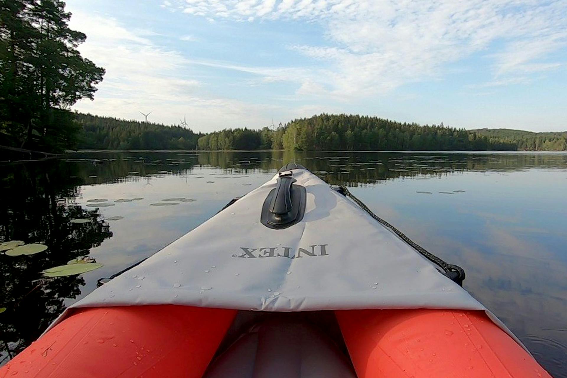 Kajak ute på en stilla sjö omgiven av skog