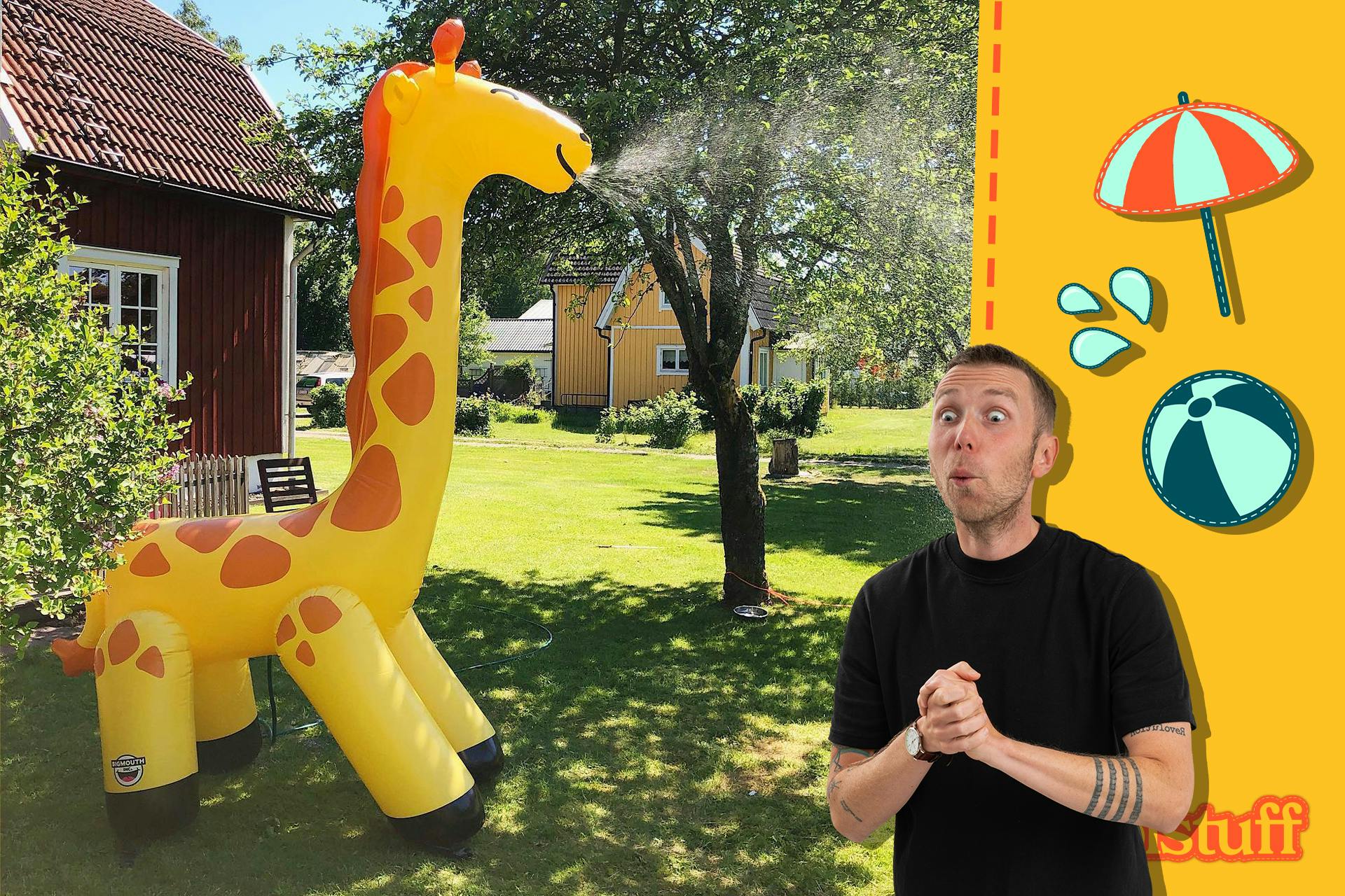 Gigantisk uppblåsbar giraff som sprutar vatten i en sommarträdgård