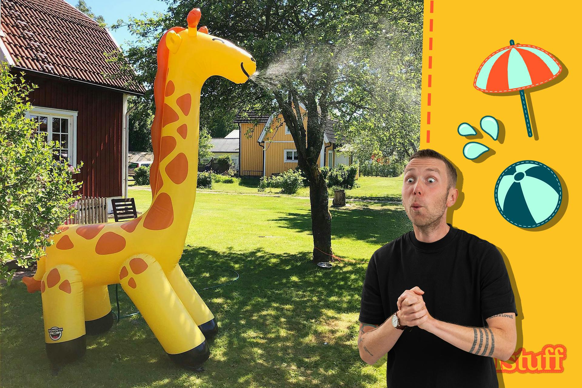 Gigantisk uppblåsbar giraff som sprutar vatten i en tädgård Coolstuff sommartema 