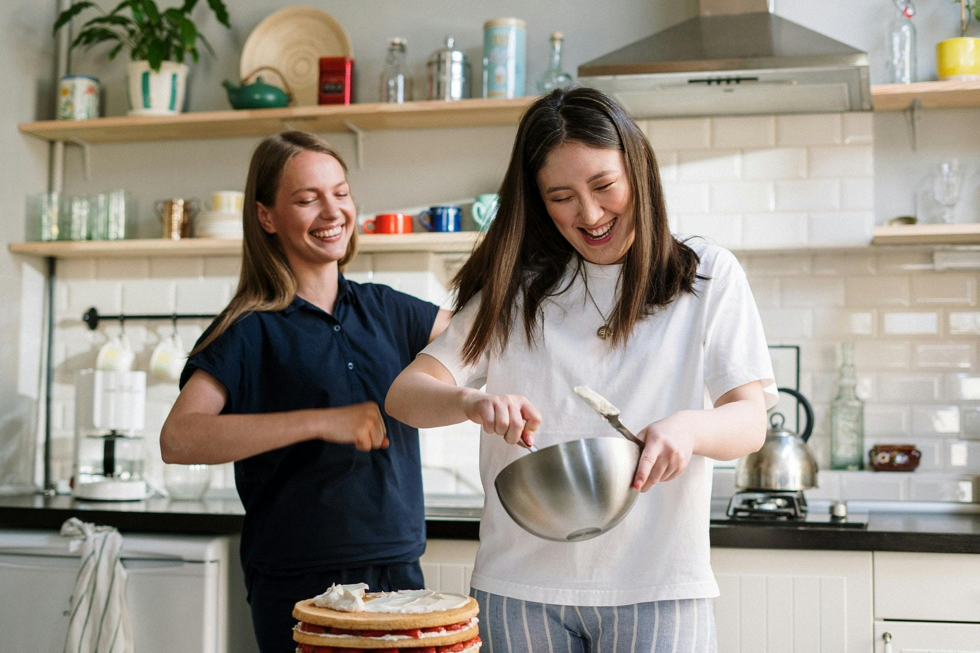 To kvinner lager mat på kjøkkenet