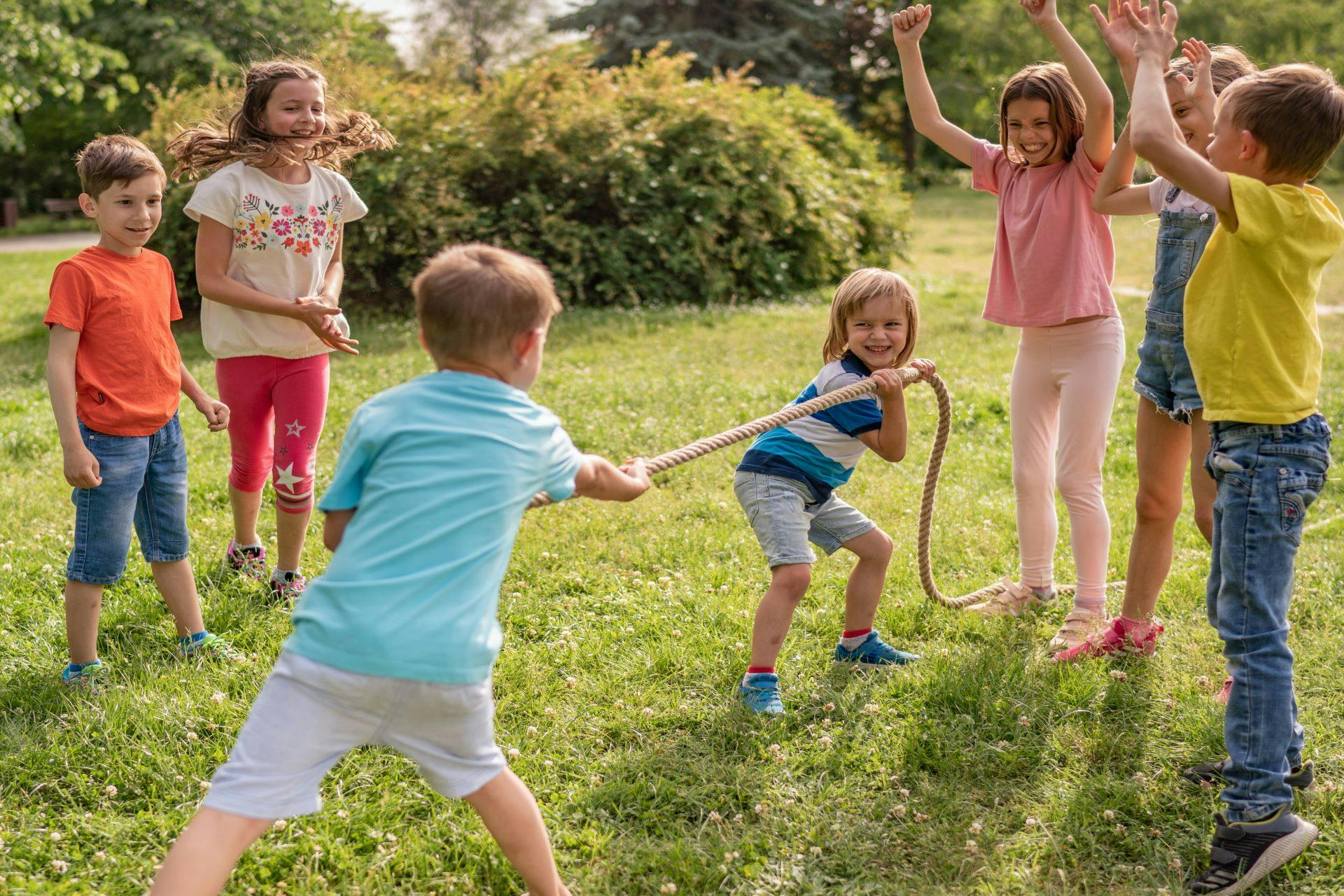 Lapset leikkivät köydenvetoa puutarhassa