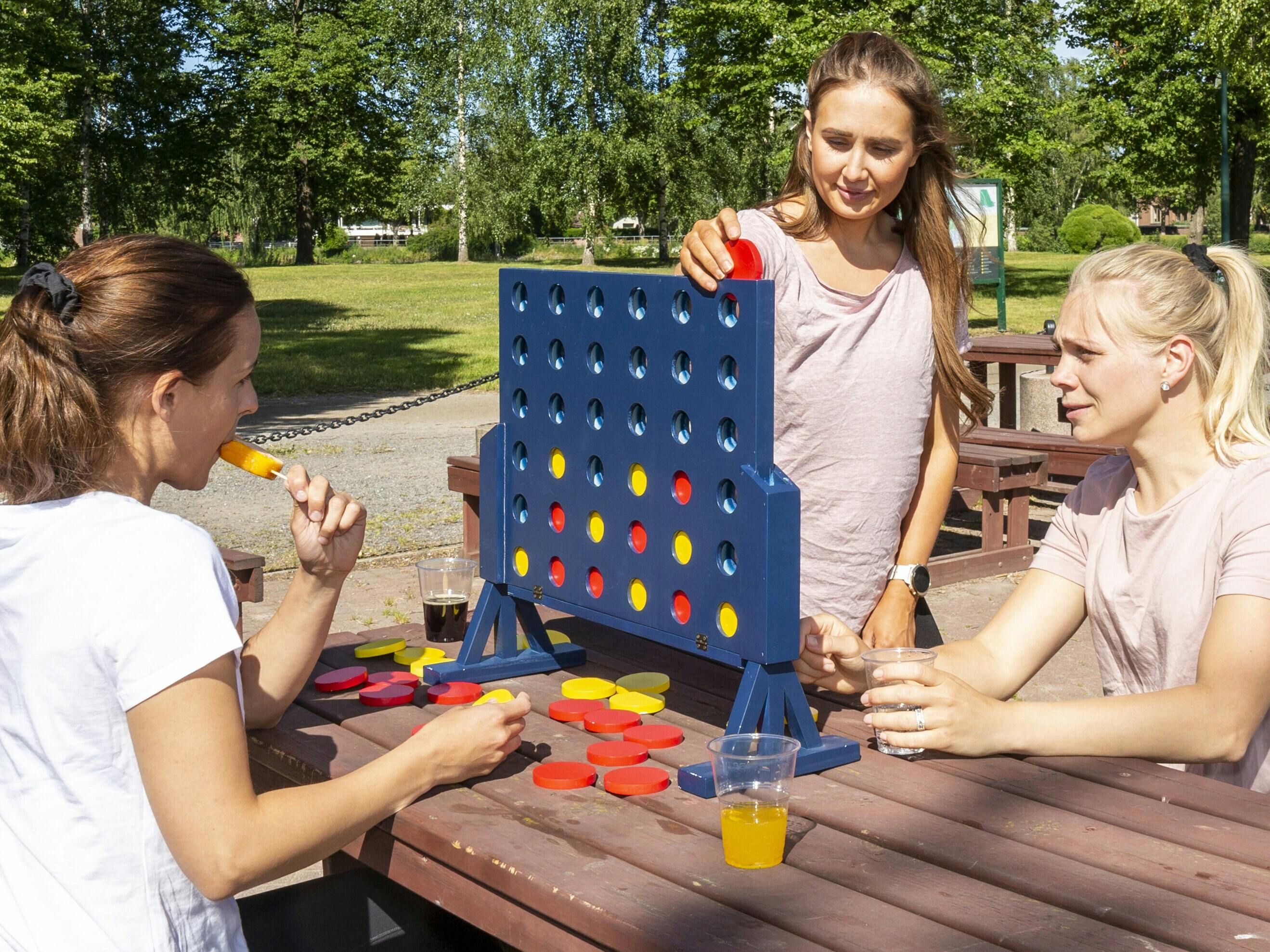 Tre personer som spelar XL fyra i rad 