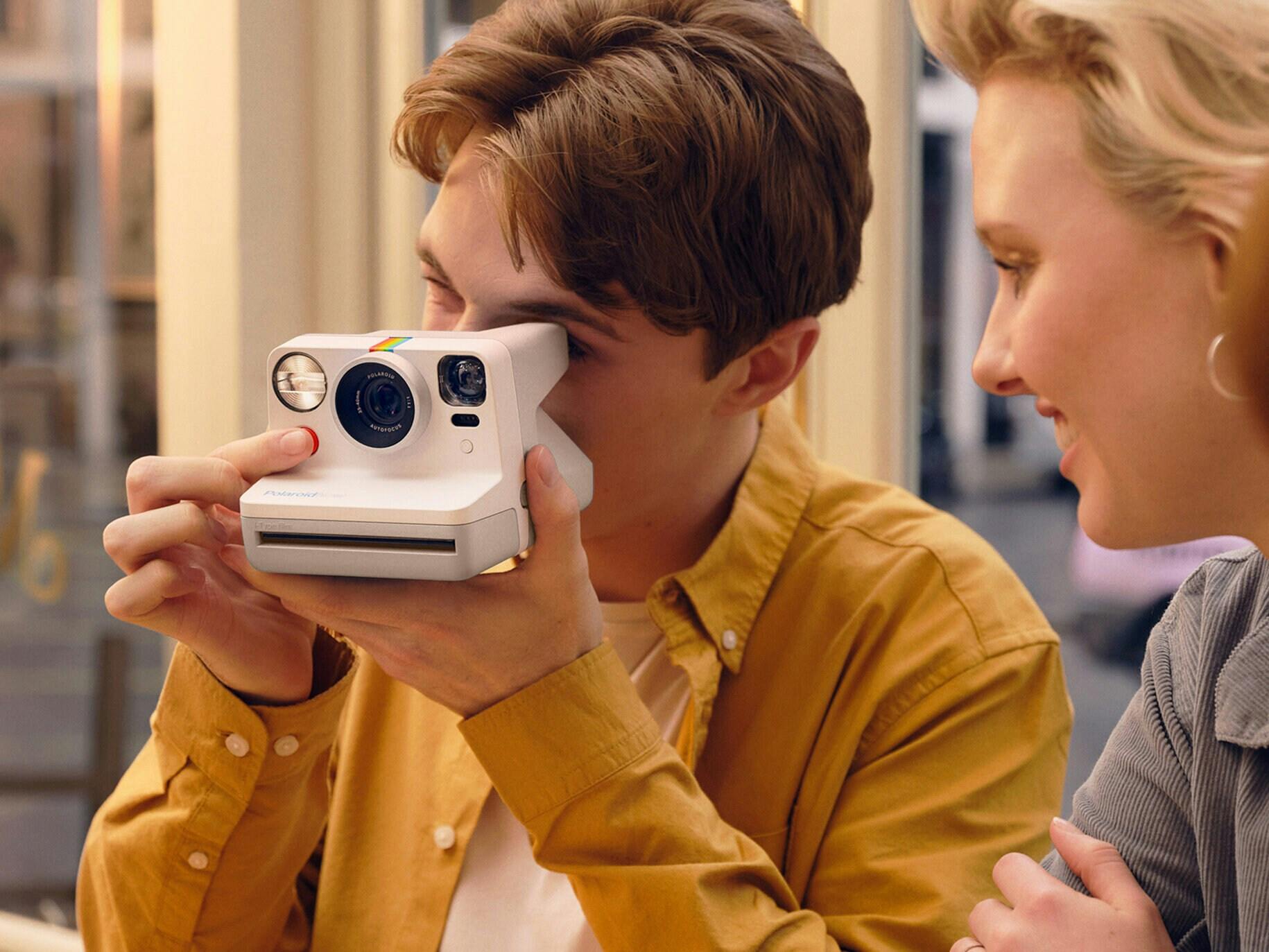  To personer, der tager billeder med et polaroid-kamera