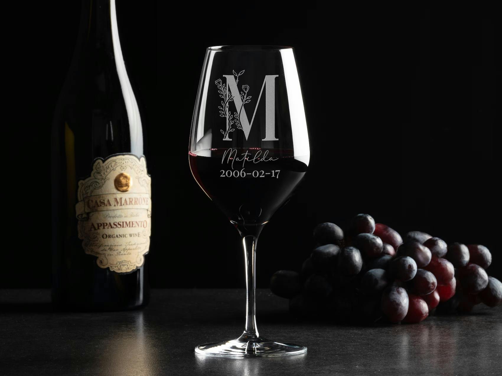 Et elegant rødvinsglas med personlig gravering, der viser modtagerens navn og en særlig dato