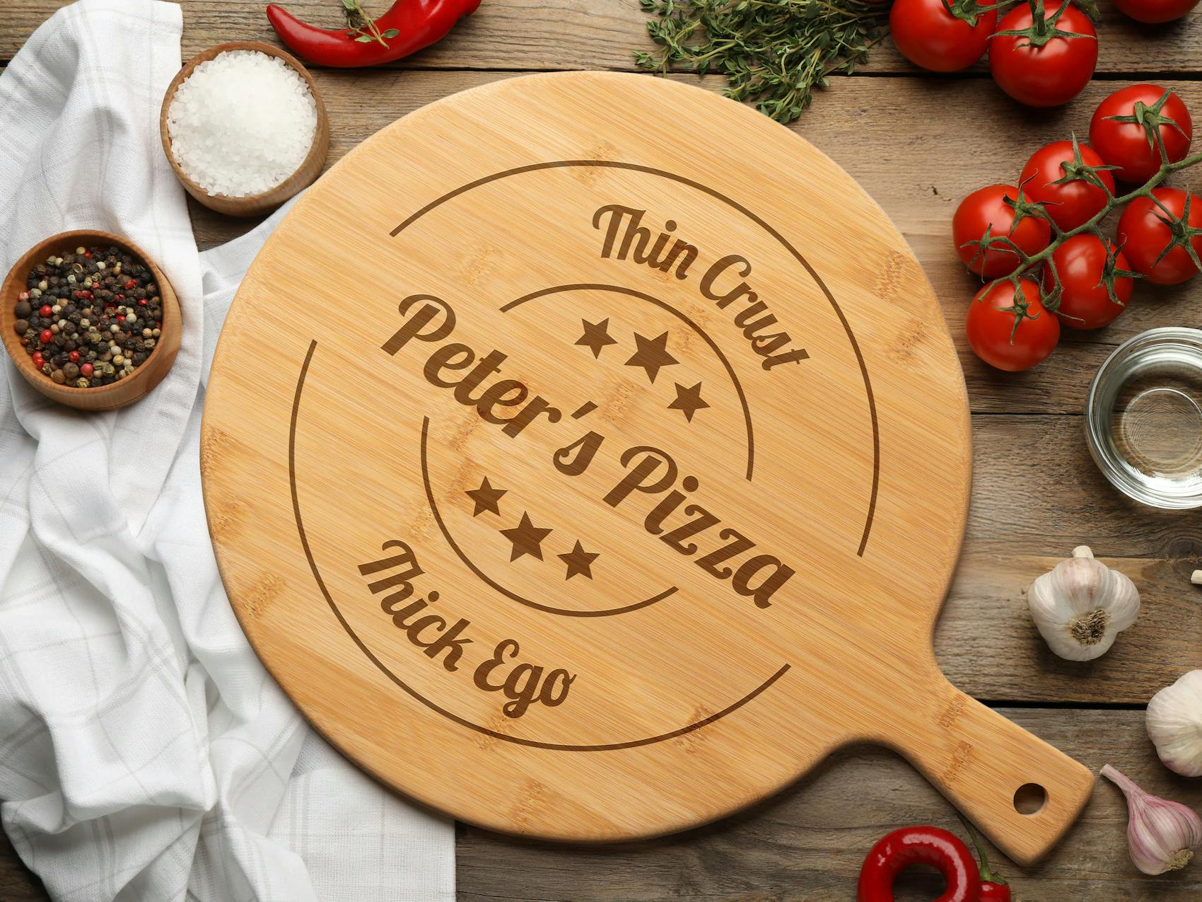 Rundt serveringsbræt til pizza i lyst træ med et personligt graveret navn og motiv.